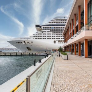 Large cruise ship beside modern building