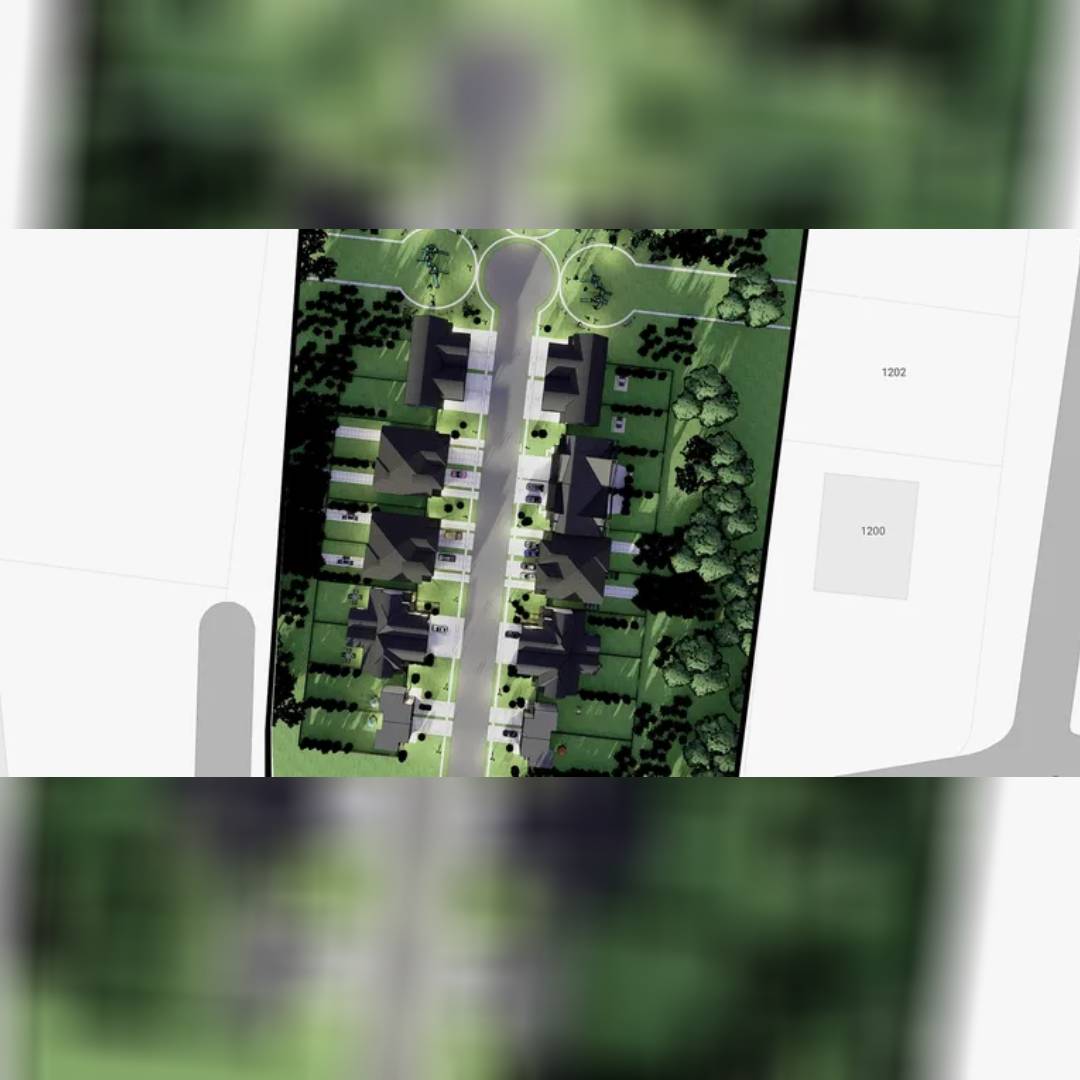 Aerial view showing a green residential area with houses and trees.