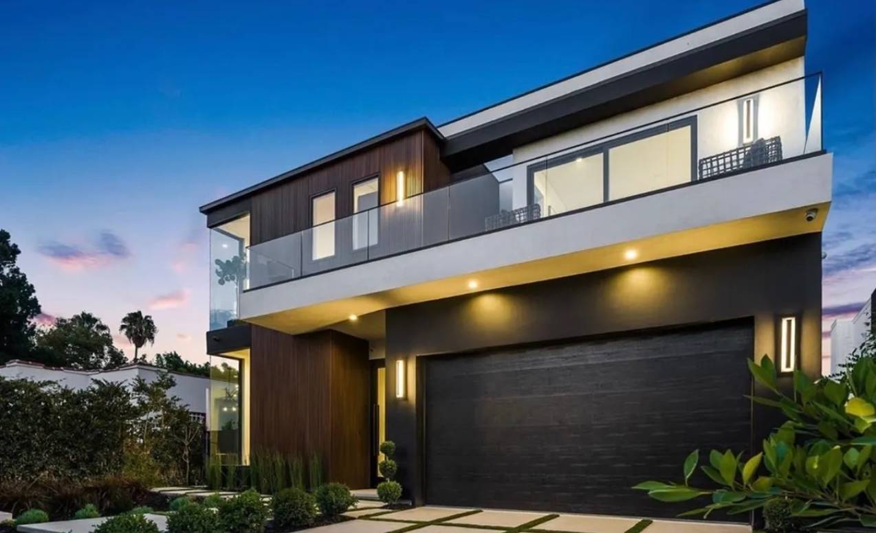 Modern two-story house with large windows and a black garage door.