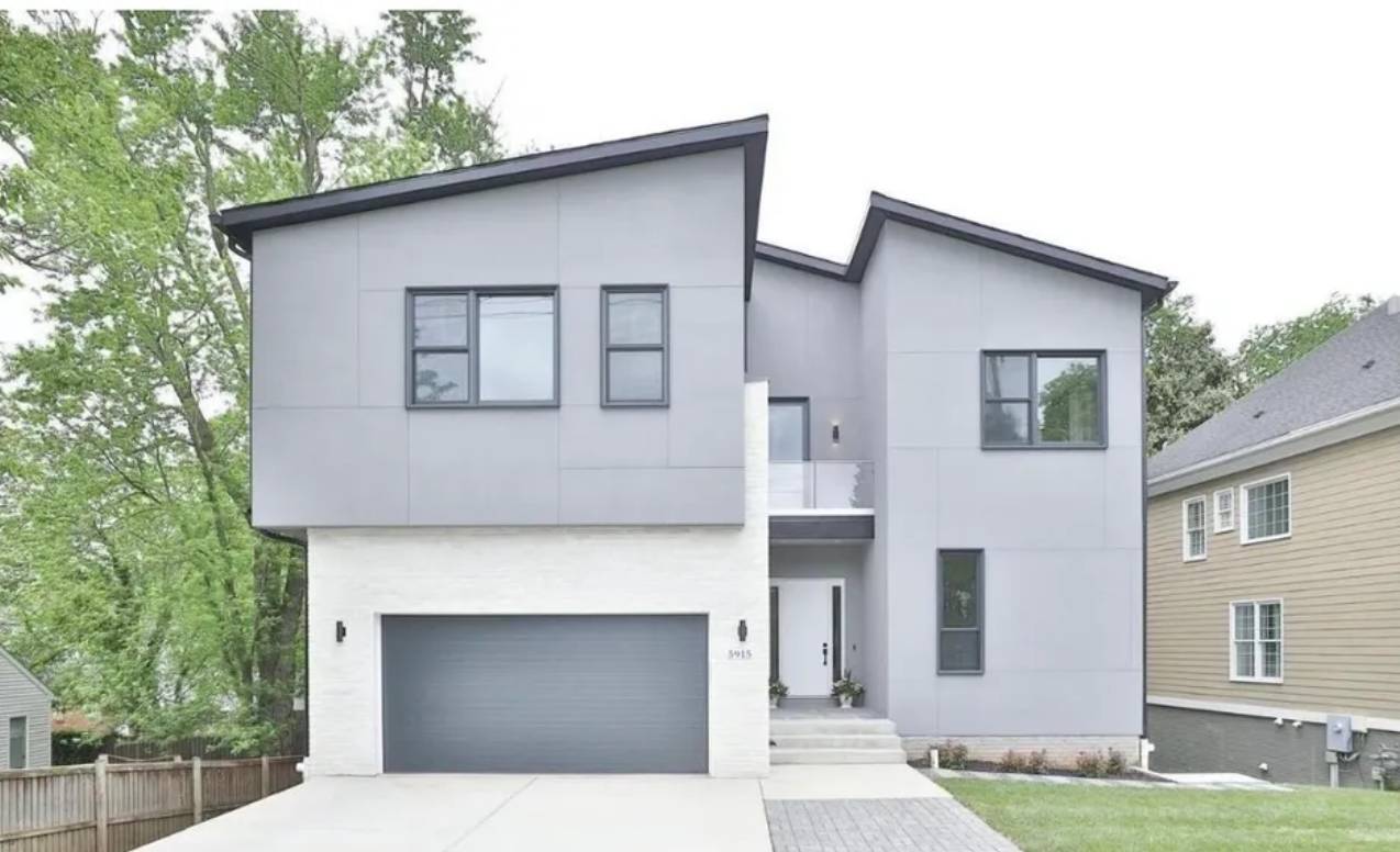 Modern two-story gray house with large windows and a double garage.