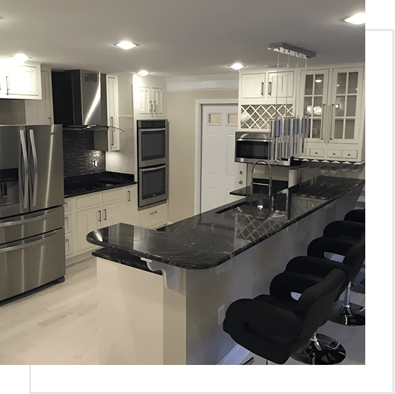 Modern kitchen with black countertops and stainless steel appliances.