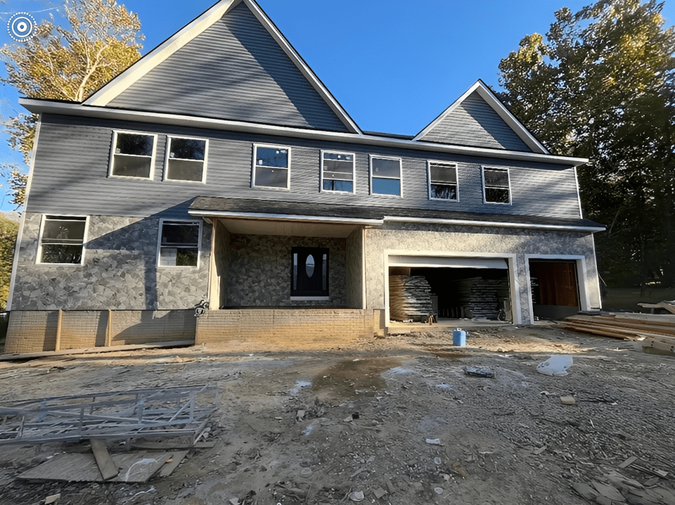 Newly constructed two-story house with a spacious garage and stone facade.